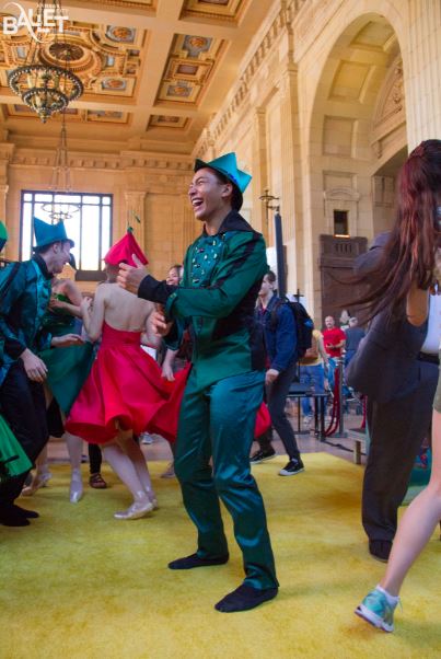 men wearing green suit, women wearing red dress, huge hall